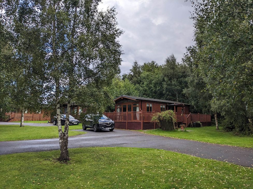 A lodge with cars parked on a driveway at Felmoor Park Northumberland Lodge with Hot Tub Felmoor Park near Felton
