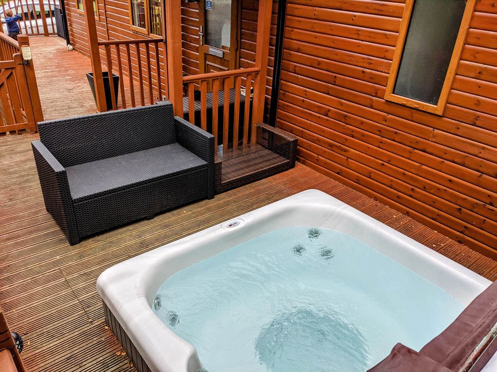 An outdoor area with a hot tub and couch at Felmoor Park Northumberland Lodge with Hot Tub Felmoor Park near Felton