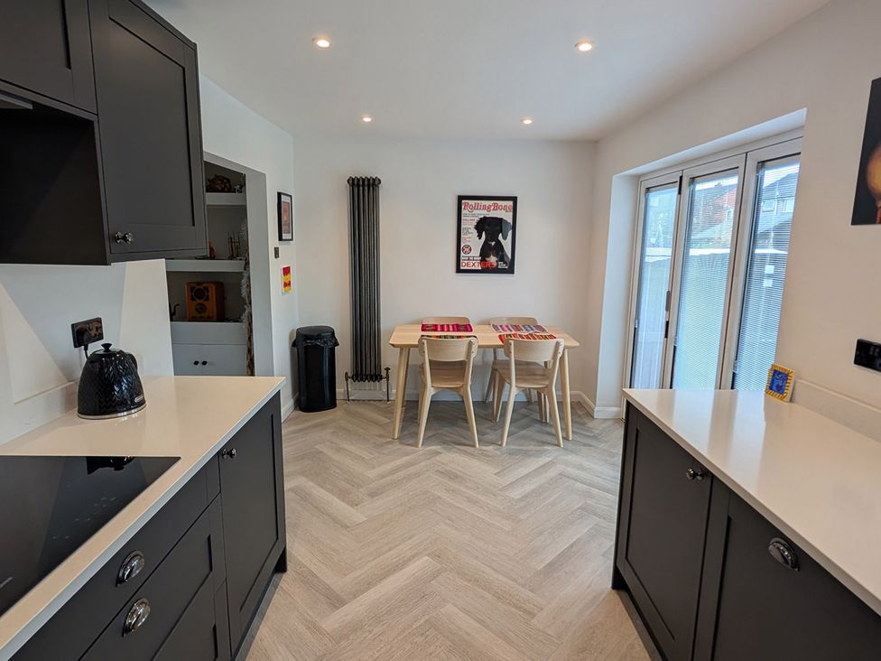 A kitchen with cabinets, countertop, table, and chairs at 3 Bed Sleeps 5 Garden Parking Pets in Carlisle