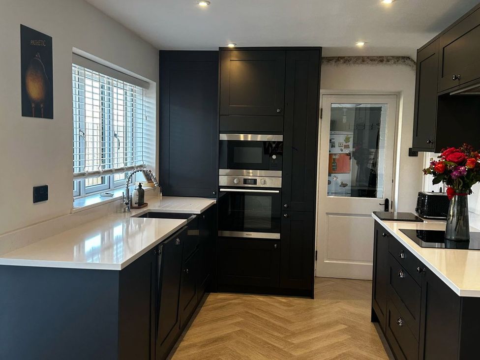 A kitchen with dark cabinets and appliances at 3 Bed Sleeps 5 Garden Parking Pets, Carlisle