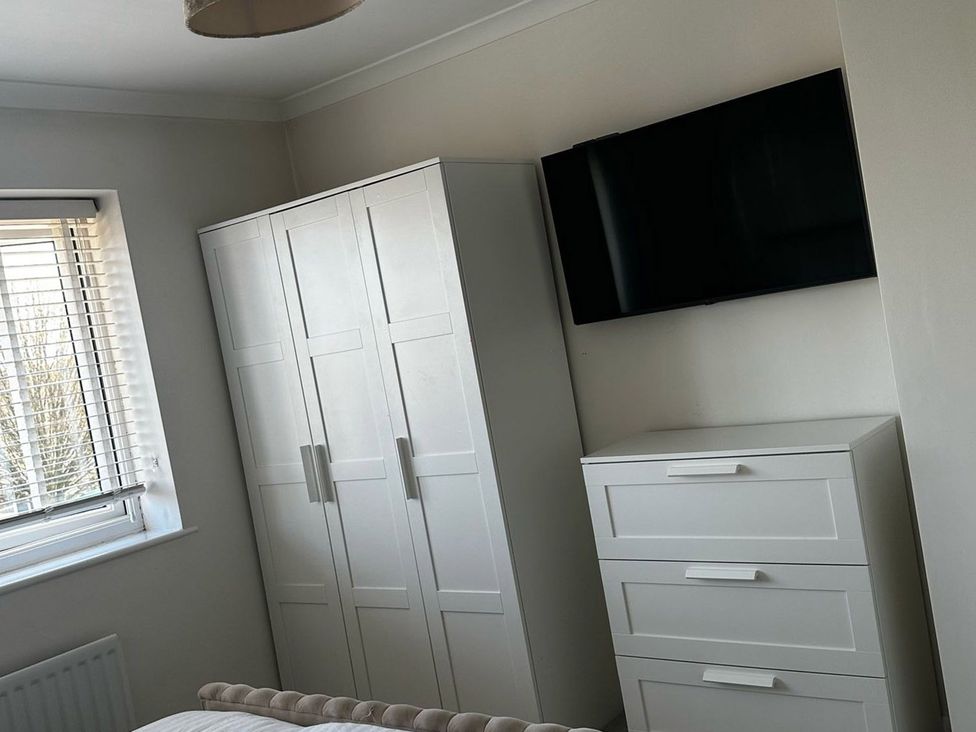 A bedroom with wardrobe, television, and chest of drawers at 3 Bed Sleeps 5 Garden Parking Pets Carlisle