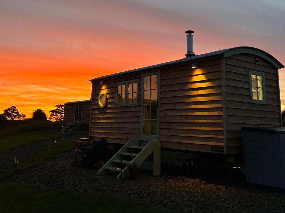 A tiny house with windows and a door at sunset at The Old Barn in Manchester