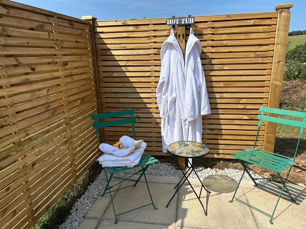 An outdoor area with a robe hanging, two chairs, and a table at the property