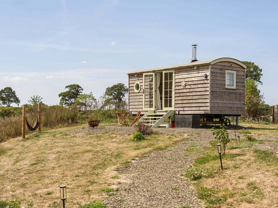 A tiny house with steps and outdoor seating at Cosy Luxury Owls Roost Hut with Private Hot Tub, Little Deptford Farm near Umberleigh