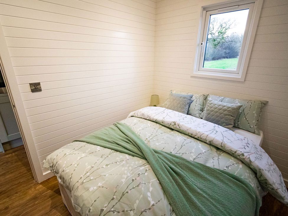 A bedroom with a bed and a window at 1Bed pod cabin in beautiful surroundings Wrexham