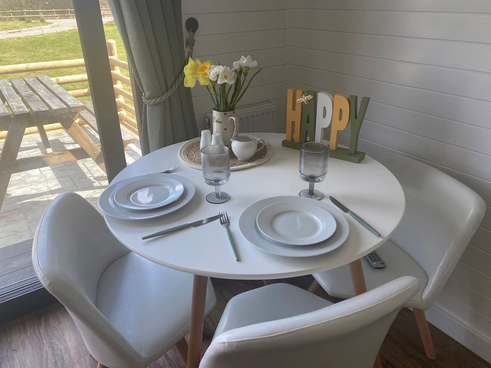 A dining room with a round table and chairs at 1Bed pod cabin in beautiful surroundings Wrexham