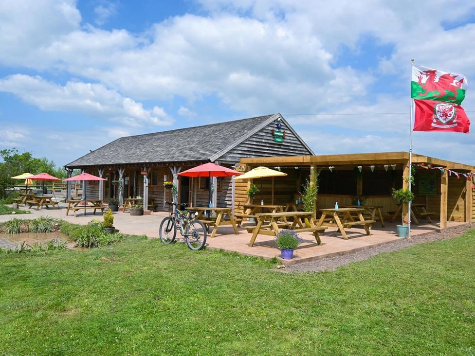 An outdoor seating area with tables and flags at 1Bed pod cabin in beautiful surroundings Wrexham