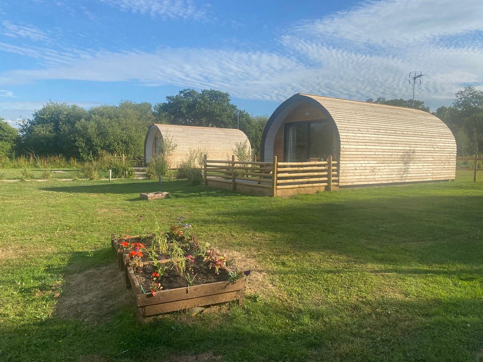 Wooden cabins and a flower garden in outdoor surroundings at 1Bed pod cabin in beautiful surroundings Wrexham