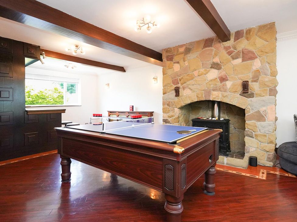 A game room with a pool table and a stone fireplace at RentMySpaHome with Swimming Pool Hot Tub and Sauna Aughton