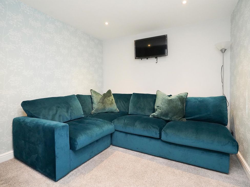 A snug with a sofa and television at RentMySpaHome with Swimming Pool Hot Tub and Sauna Aughton