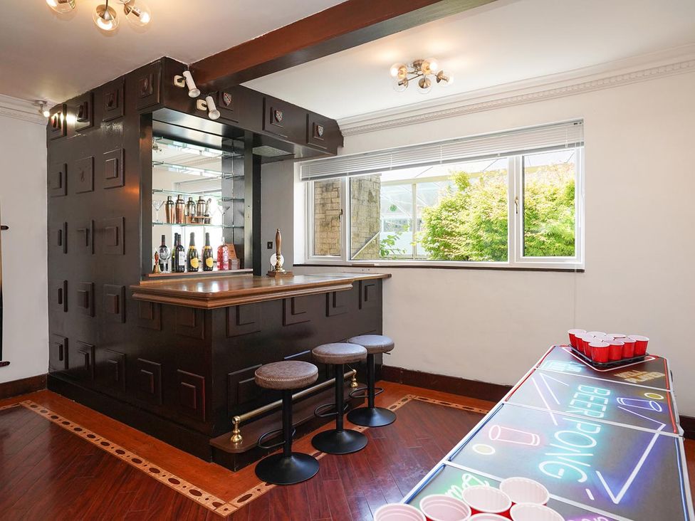A game room with a bar and ping pong table at RentMySpaHome with Swimming Pool Hot Tub and Sauna Aughton
