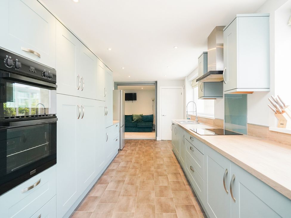 A kitchen with cabinets and appliances at RentMySpaHome with Swimming Pool Hot Tub and Sauna Aughton