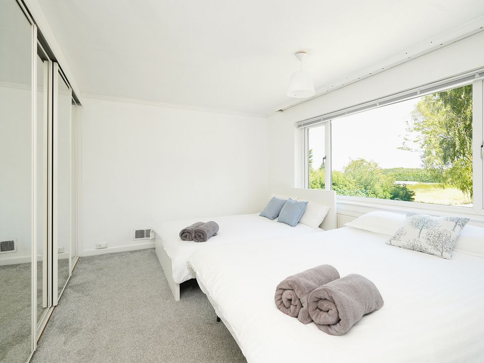 A bedroom with two beds and a window at RentMySpaHome with Swimming Pool Hot Tub and Sauna Aughton