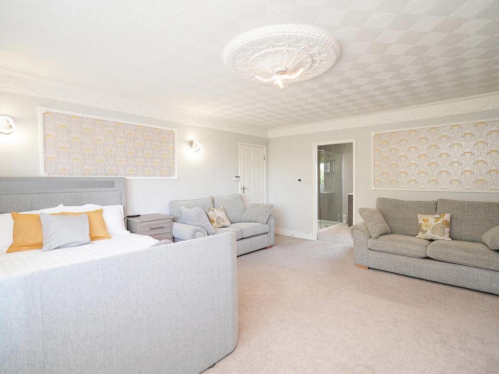 A living room with a bed and sofas at RentMySpaHome with Swimming Pool Hot Tub and Sauna Aughton