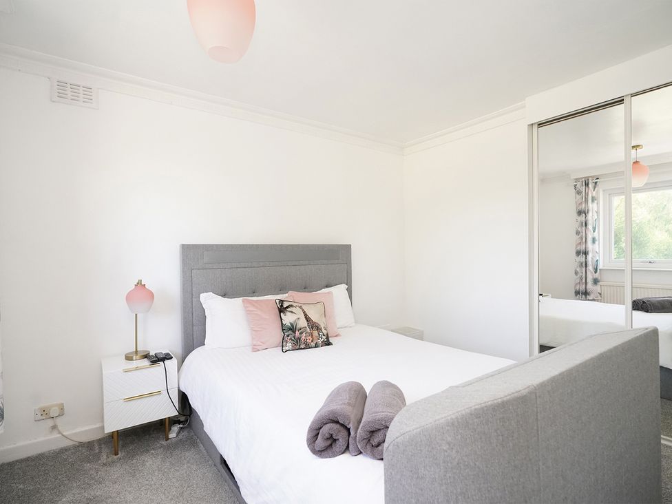 A bedroom with a bed and bedside lamp at RentMySpaHome with Swimming Pool Hot Tub and Sauna Aughton