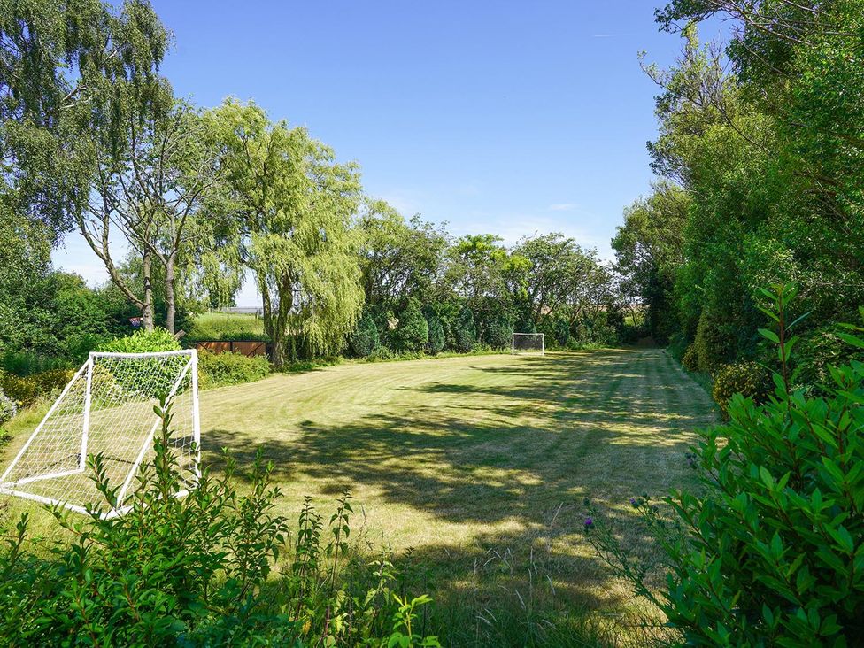 A garden with a grass field and goal posts at RentMySpaHome with Swimming Pool Hot Tub and Sauna Aughton