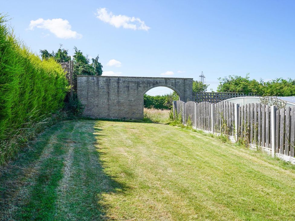 A garden with a wall and fence at RentMySpaHome with Swimming Pool Hot Tub and Sauna Aughton