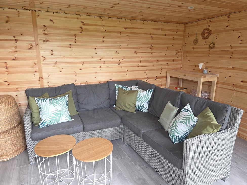 A snug with a sofa and side tables at RentMySpaHome with Swimming Pool Hot Tub and Sauna Aughton