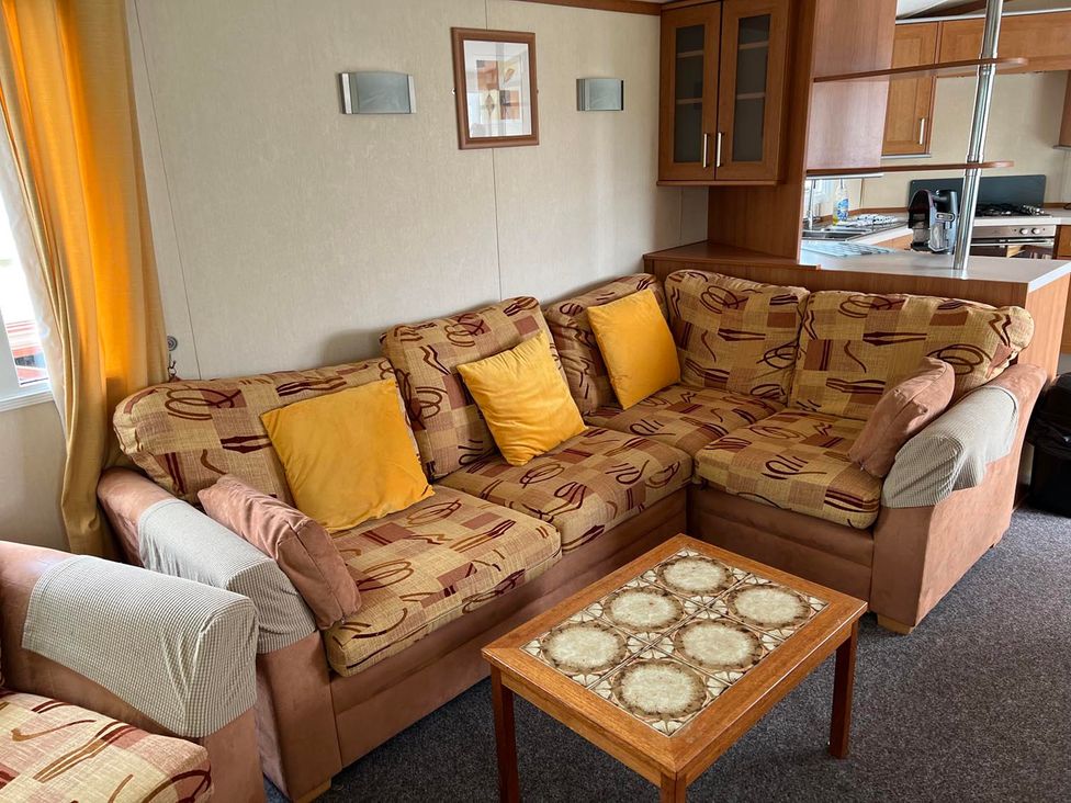 A living room with a sofa and coffee table at Cozy 2 bedroom Coastal Chalet in Heacham