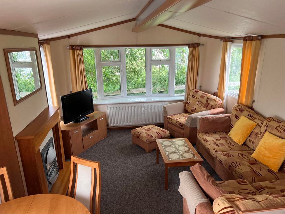 A living room with a television and seating area at Cozy 2 bedroom Coastal Chalet in Heacham
