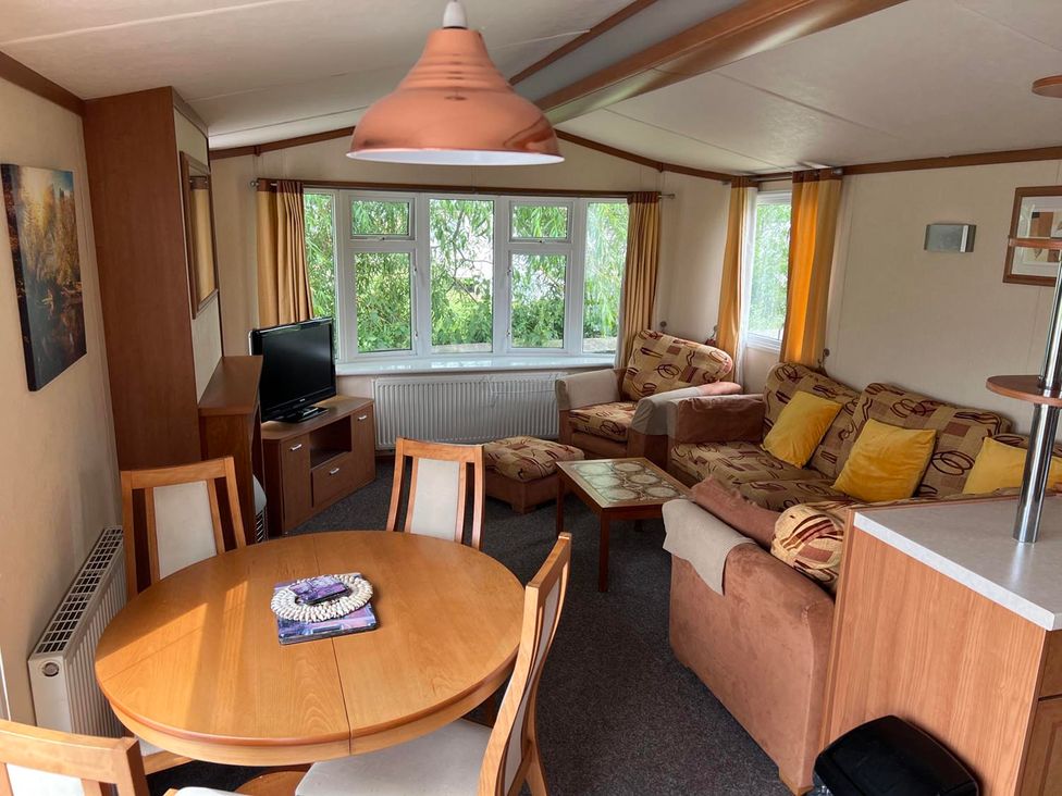 A living room with a dining table and sofa at Cozy 2 bedroom Coastal Chalet in Heacham