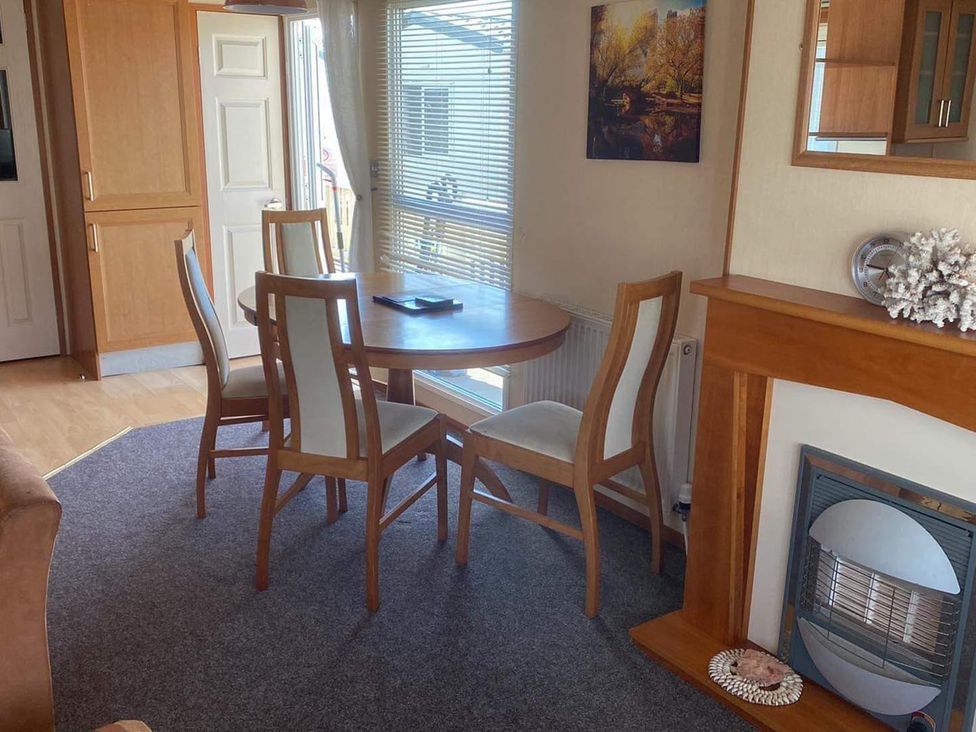 A dining room with a table and chairs at Cozy 2 bedroom Coastal Chalet in Heacham