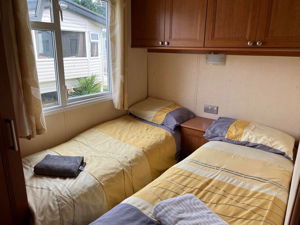 A bedroom with two beds and a window at Cozy 2 bedroom Coastal Chalet in Heacham