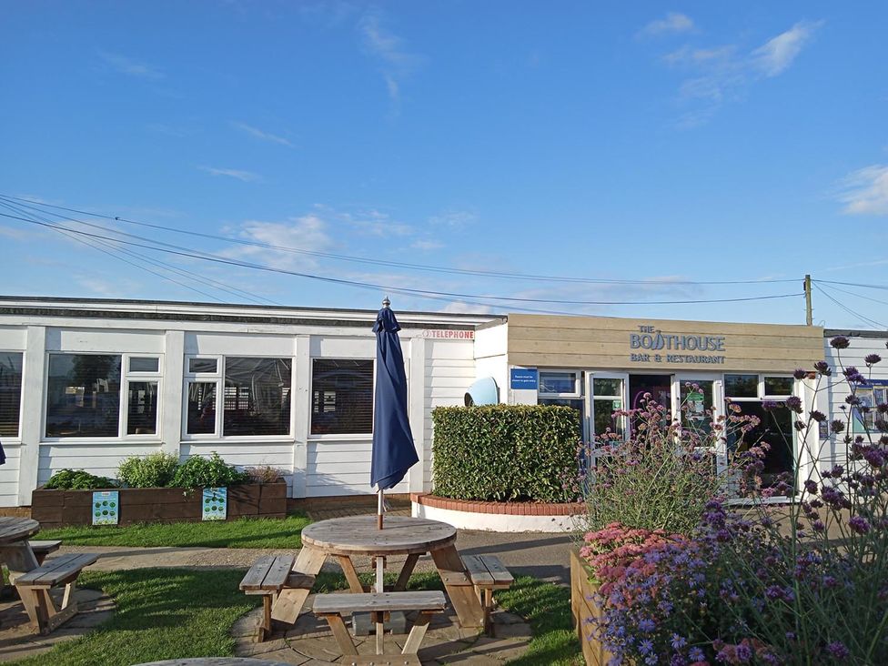 An outdoor seating area with tables and umbrellas at The Boathouse in Heacham