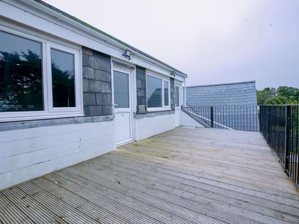 An outdoor area with wooden decking and windows at 1 Bedroom Apartment Sleeps 2 Pets Welcome in Carbis Bay