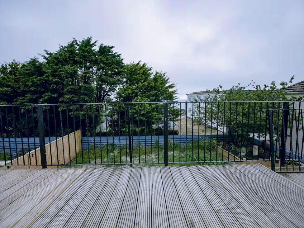 An outdoor area with wooden decking and a view of trees and grass at 1 Bedroom Apartment Sleeps 2 Pets Welcome Carbis Bay
