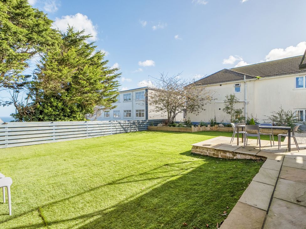 A garden with grass and outdoor seating at 1 Bedroom Apartment Sleeps 2 Pets Welcome in Carbis Bay