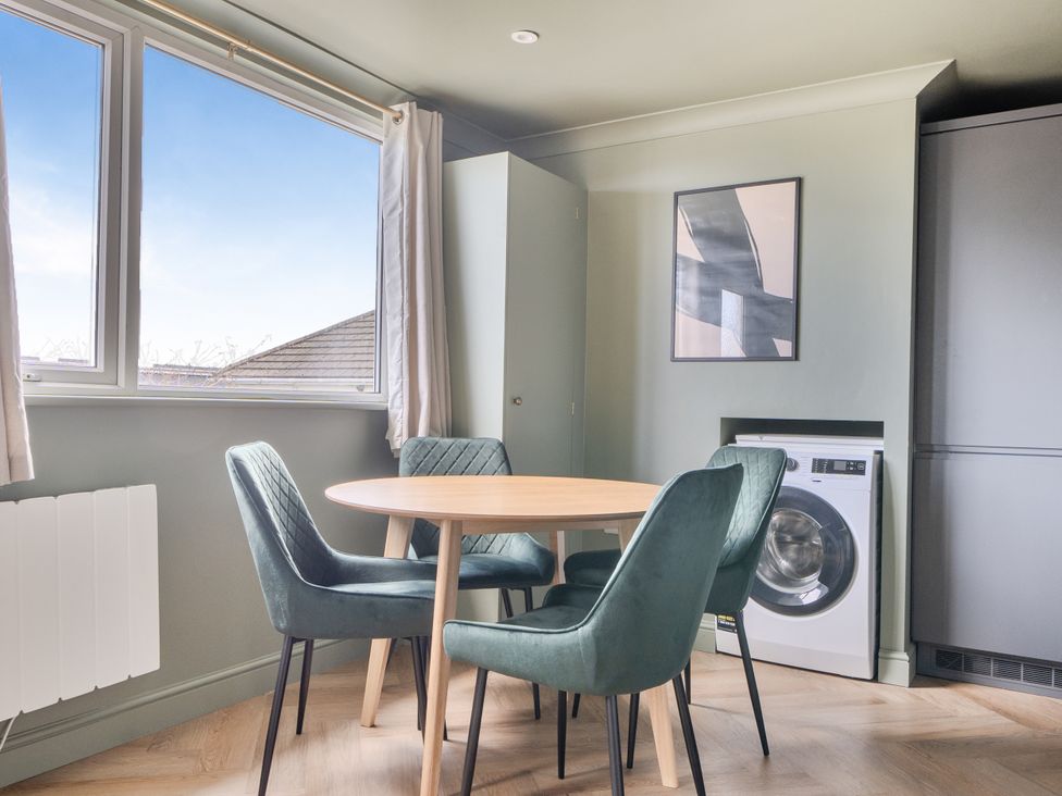 A kitchen with a table and chairs and a washing machine at 1 Bedroom Apartment Sleeps 2 Pets Welcome in Carbis Bay
