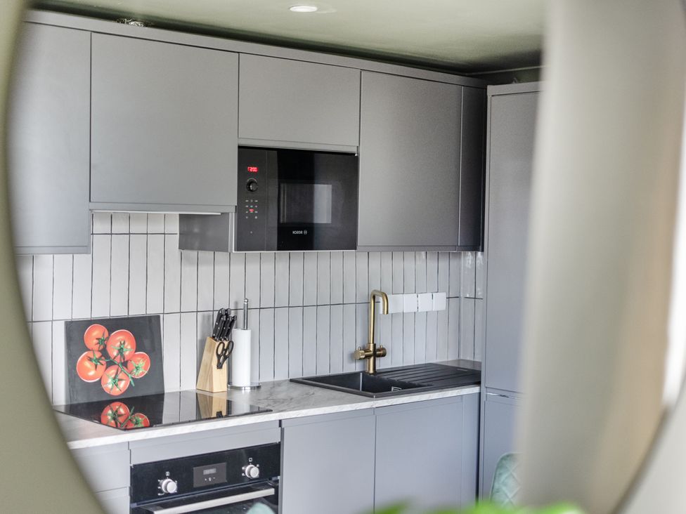 A kitchen with cabinets, stove, sink, and wall art at 1 Bedroom Apartment Sleeps 2 Pets Welcome in Carbis Bay