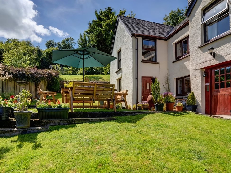 A garden with a table and chairs under an umbrella at a house