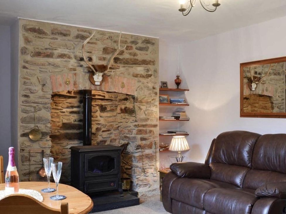 A living room with a stove and dining table at The Old Barn in Manchester