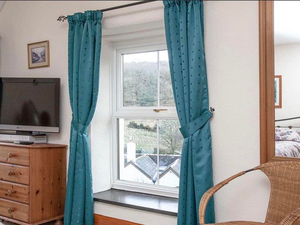 A bedroom with a window, television, and chest of drawers at The Old Barn in Manchester