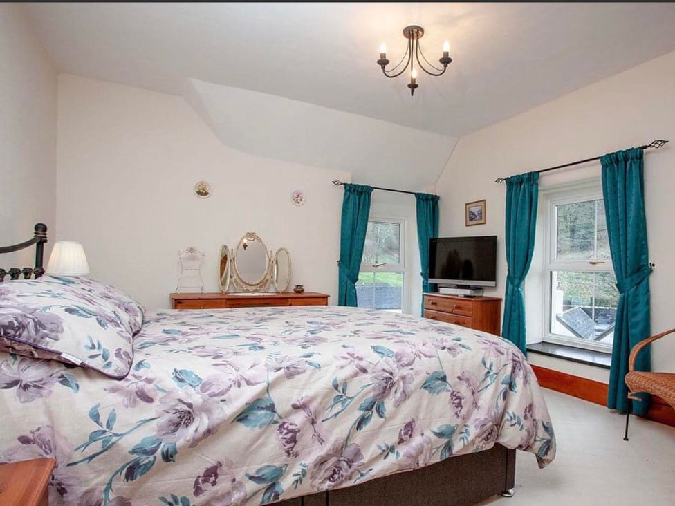 A bedroom with a bed, dresser, and television at the property in location