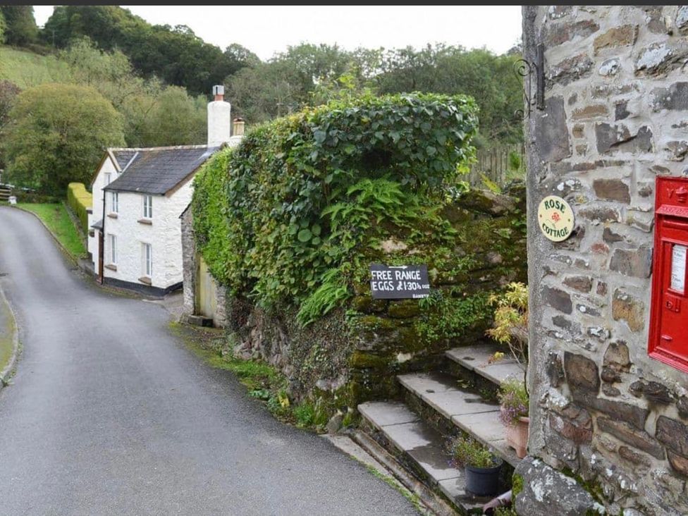 A house with a mailbox and steps at Rose Cottage in an outdoor setting
