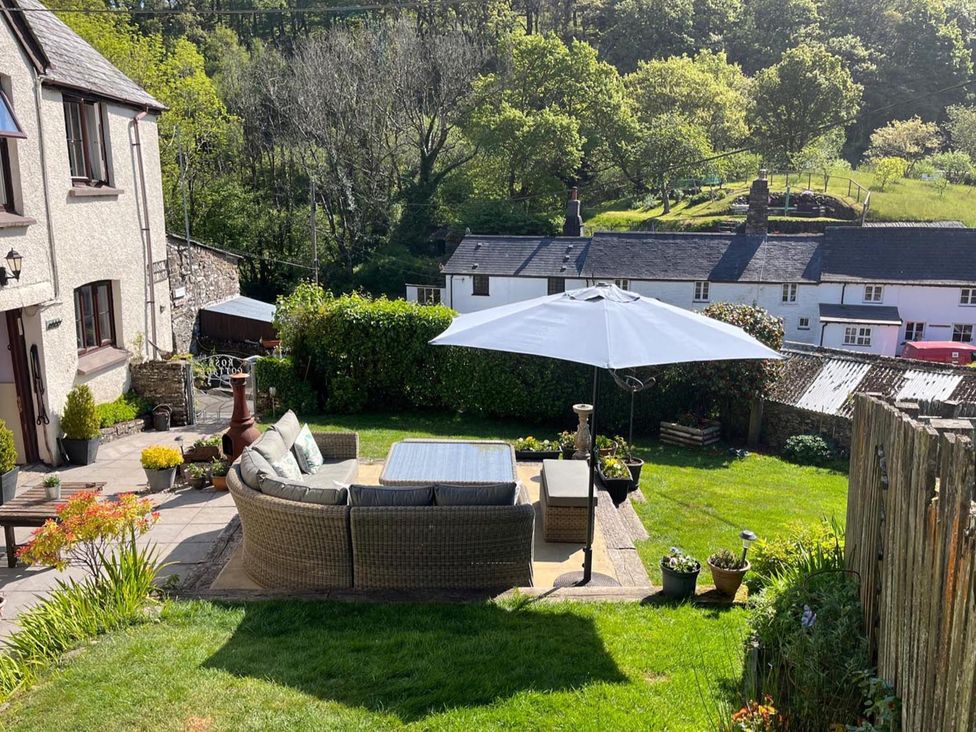 A garden with a seating area and umbrella at a property in the countryside