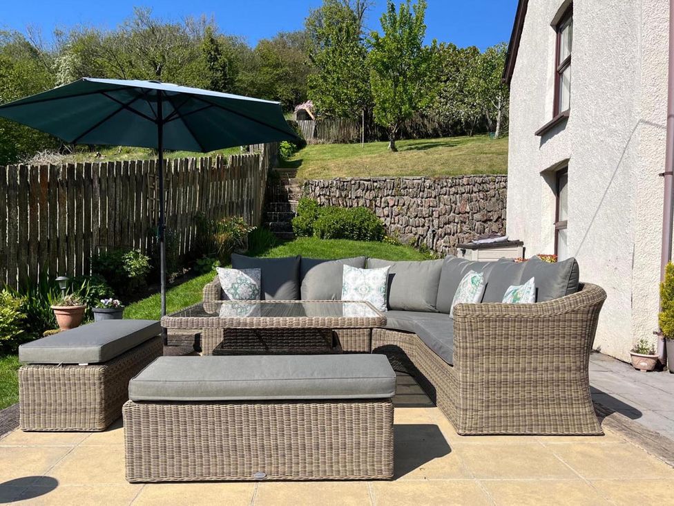 A seating area with a sofa and umbrella in an outdoor space at an unspecified location