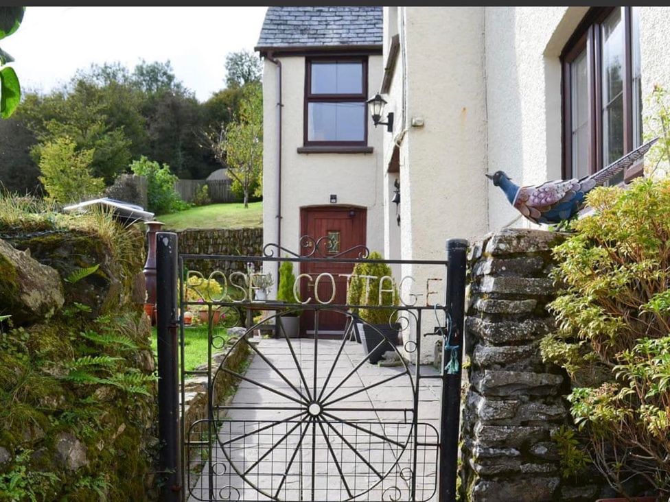 A cottage entrance with a gate and pathway at Rose Cottage