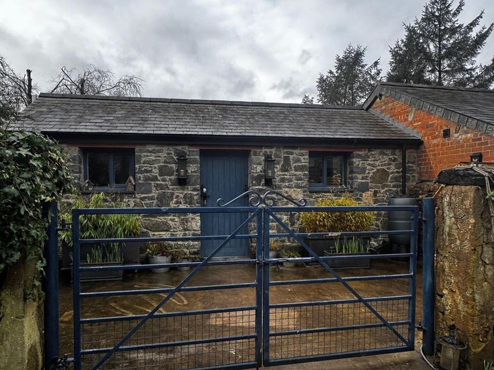 A stone building with a blue door and plants in front at the property location