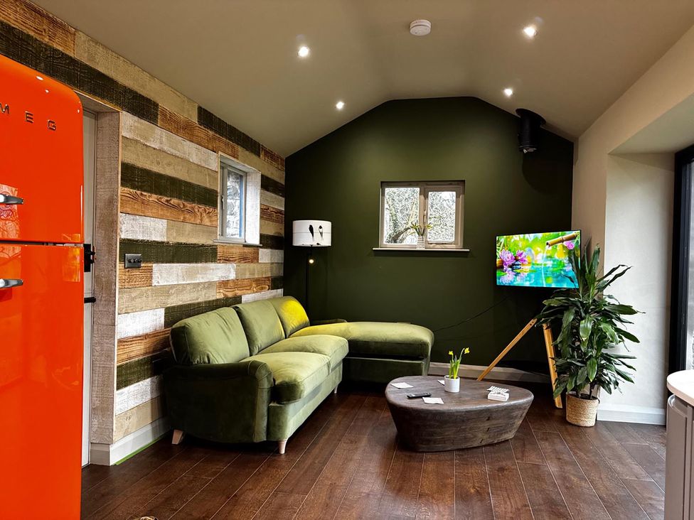 A living room with a green sofa and a television at a property