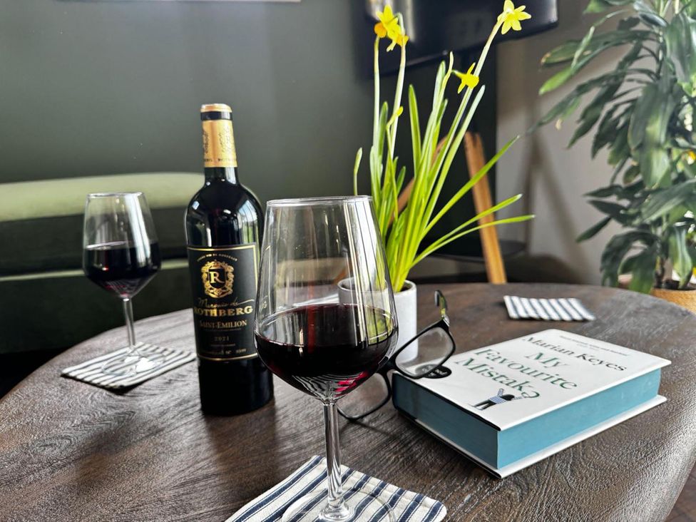 A table with wine glasses and a book in a living room