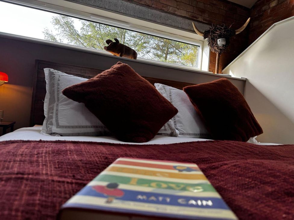 A bedroom with a bed and a book on it at The Old Barn in Manchester