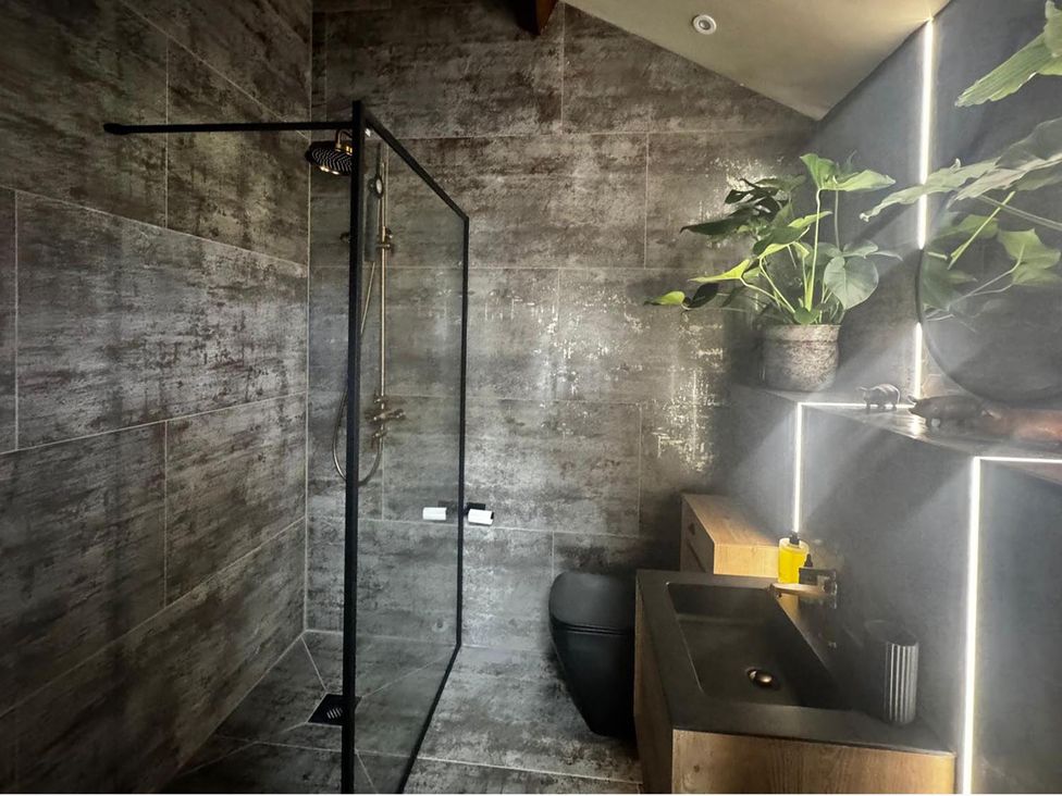A bathroom with a shower and sink at the property in location