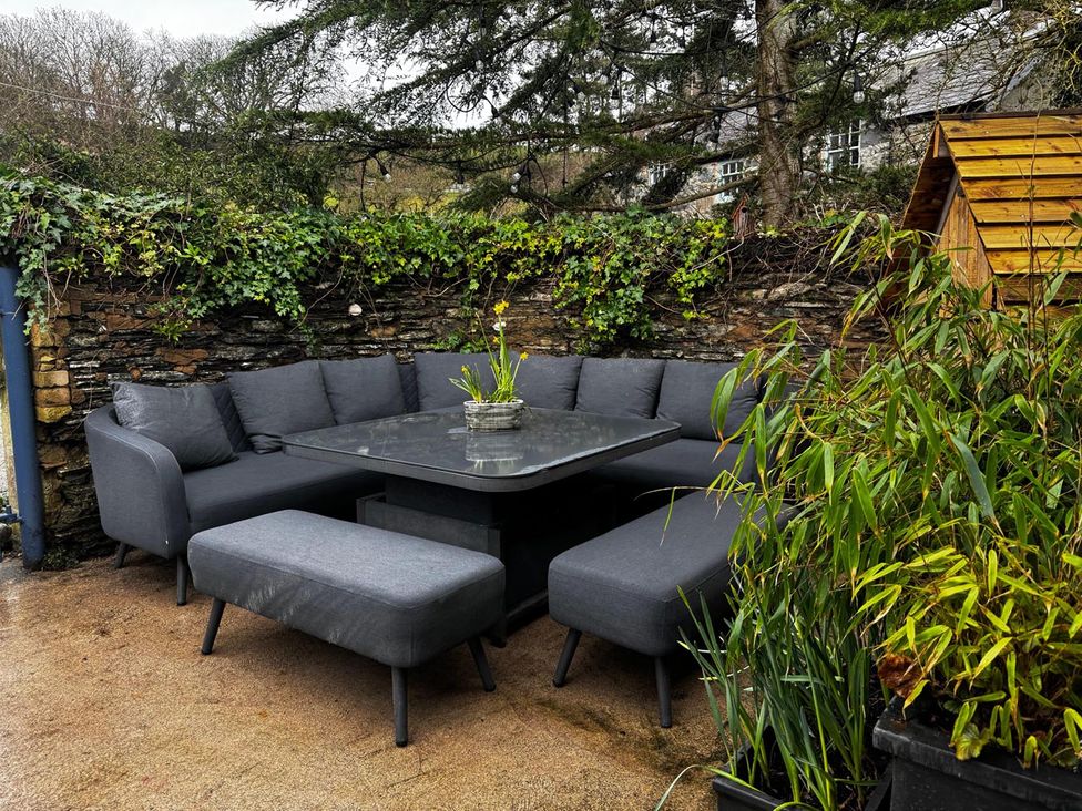 A seating area with a sofa and table in a garden