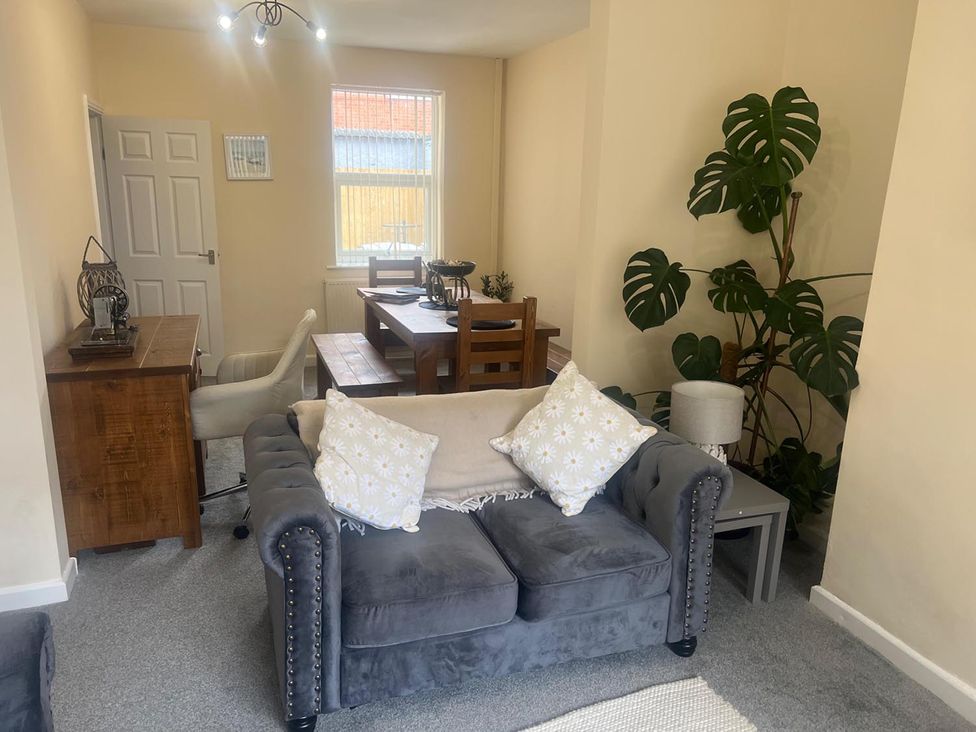 A living room with a sofa and dining table at The Old Barn in Manchester