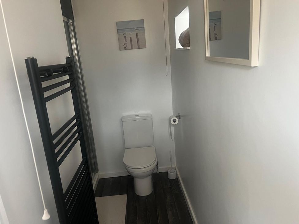 A bathroom with a toilet and towel warmer at The Old Barn in Manchester