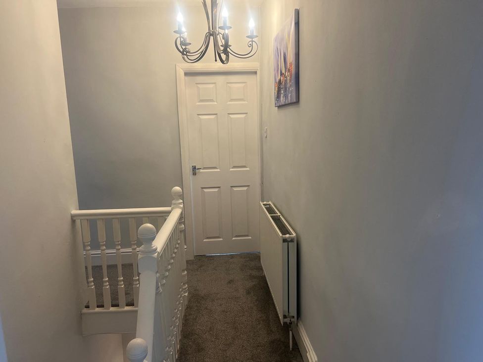 A hallway with a chandelier and door at the property in 